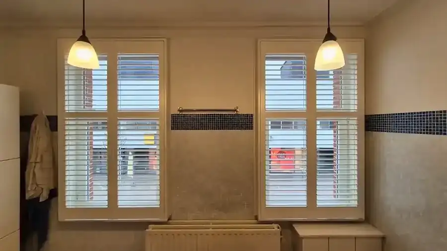 Shutters blancs devant deux fenêtres de salle de bains à Balen