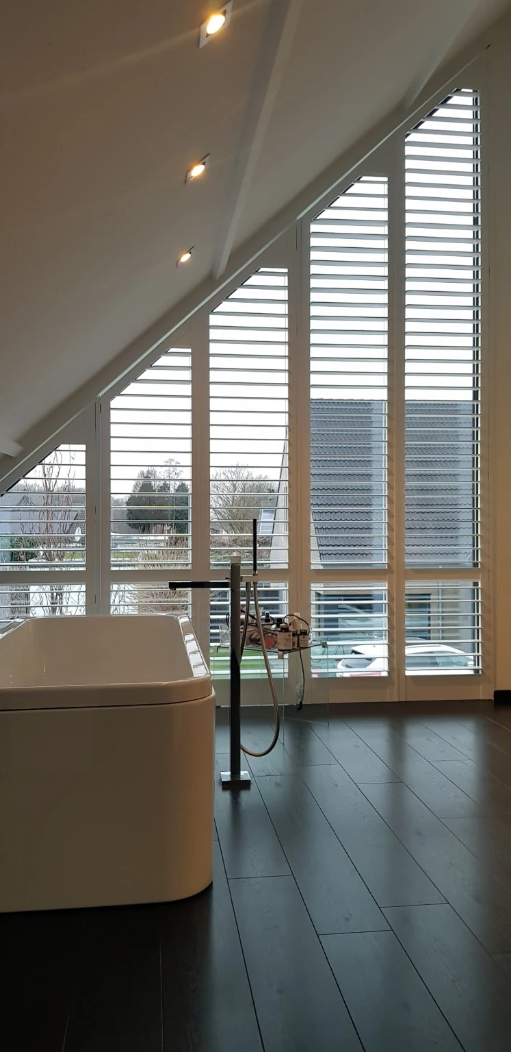 White shutters for the tall, sloping bathroom window in Haacht, with 89 mm louvres and ClearView — project photo 3