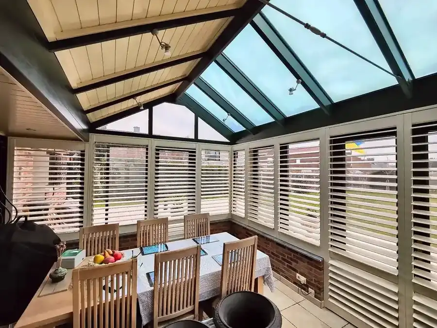 Weiße Shutters rund um einen hellen Wintergarten in Kortenberg